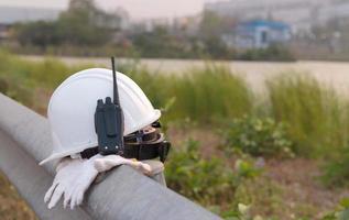 radiozender en witte helm, ingenieur of veiligheidsuitrusting voor werknemers. foto