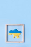 kaart van oekraïne in geelblauwe kleuren van de oekraïense vlag in een houten frame foto