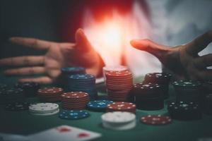 Aziatische vrouw dealer of croupier schudt pokerkaarten in een casino op de achtergrond van een tafel, zoals een vrouw met twee speelkaarten. casino, poker, pokerspelconcept foto