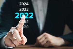 nieuwjaarsconcept 2022 handaanraking op een virtueel scherm 2022. foto