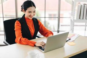 zakelijke Aziatische vrouw werkt met een gelukkige glimlach en concentratie aan het werk foto