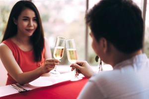 Aziatische minnaar paar man en vrouw hand houden een champagnedrankje op valentijn foto
