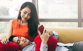 romantische Aziatische paar ontspannen samen in de woonkamer. eenvoudige activiteit thuis. foto