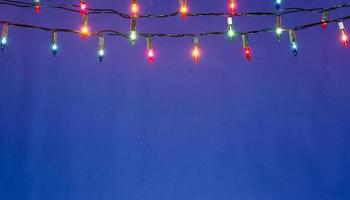 kerstverlichting string op blauwe achtergrond met kopie ruimte foto