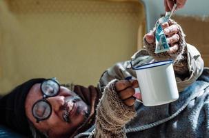dakloze man is blij een gelddonatie te ontvangen, omdat hij werkloos en dakloos is vanwege de covid 19-epidemie. foto