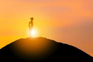 silhouet van jonge vrouw met uitknippad beoefenen van yoga ontspannende oefening bij zonsondergang, vrijheid en ontspannen concepten. foto