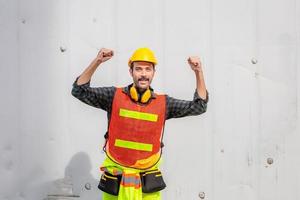 ingenieur man in veiligheidshelm en veiligheidsvest die de overwinning viert op de bouwplaats foto