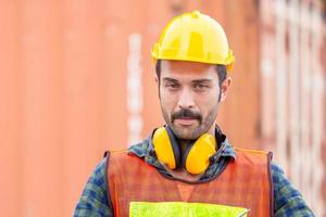 portret van ingenieur man in harde hoed en veiligheidsvest, arbeider met beschermende koptelefoon op bouwplaats foto