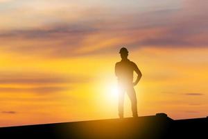 silhouet van een bedrijfsingenieur die op de avondzonsondergang van de containerdoos staat foto