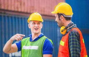 gelukkig ingenieur en arbeidersteam die containersdoos van lading controleren met vage achtergrond, groepswerkconcept foto