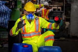 ingenieursindustrie die veiligheidsuniform draagt, zwarte handschoenen, gasmasker voelt stikken bij het controleren van chemische tank in fabriekswerk in de industrie. foto