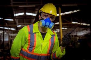 ingenieursindustrie die veiligheidsuniform draagt, zwarte handschoenen, gasmasker voelt stikken bij het controleren van chemische tank in fabriekswerk in de industrie. foto