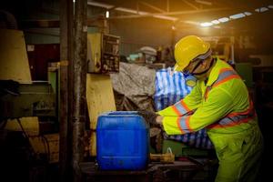 ingenieursindustrie die veiligheidsuniform draagt, zwarte handschoenen, gasmasker voelt stikken bij het controleren van chemische tank in fabriekswerk in de industrie. foto