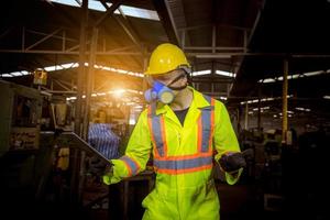 ingenieursindustrie die veiligheidsuniform draagt, zwarte handschoenen, gasmasker voelt stikken bij het controleren van chemische tank in fabriekswerk in de industrie. foto