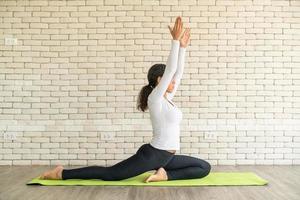 latijnse vrouw die yoga beoefent op mat foto