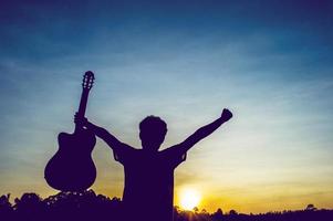 silhouet van een gitarist in de schaduw bij zonsondergang licht, silhouet concept. foto