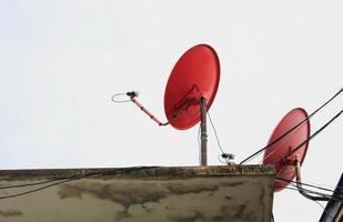 twee rode satellietschotels op het dak foto