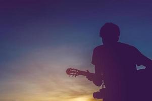 silhouet van een gitarist in de schaduw bij zonsondergang licht, silhouet concept. foto