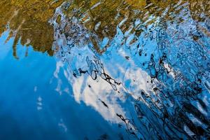 herfstweerspiegeling van een boom in het meer foto