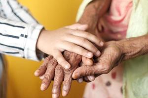 close-up van de hand van een kind met de hand van senior vrouwen foto