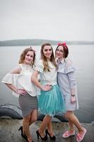 fantastische bruid met haar twee bruidsmeisjes op de kade naast het meer op vrijgezellenfeest. foto