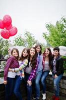 groep van zes meisjes die plezier hebben op vrijgezellenfeest, met ballonnen onder regen. foto