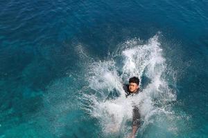 een man die in de zee springt en het water spettert foto