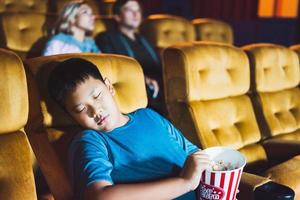 Aziatische jongen slapen in een bioscoop. foto