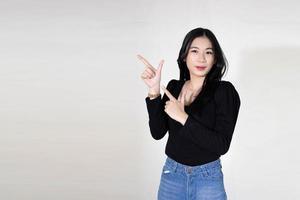 Mooie glimlachende jonge Aziatische vrouw die duimen opgeeft, studio-opname geïsoleerd op een witte achtergrond foto