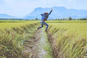 aziatische man reizen ontspannen in de vakantie. spring natuurlijke aanraking bergveld. spring staan blij midden veld rijst. Thailand foto