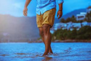 aziatische man reizen natuur. reizen ontspannen. lopen op het strand. in de zomer foto