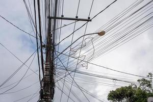 een warboel van kabeldraden gespannen langs elektriciteitsmasten die veel voorkomen in brazilië en latijns-amerikaanse landen foto