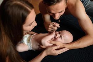 jonge ouders hebben plezier met hun zoontje foto