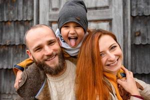 een gelukkige familie zit op de trap voor de ingang van het huis. foto