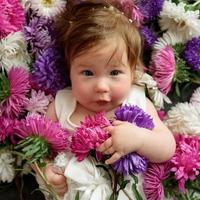 babymeisje in blauwe jurk spelen met bos roze tulpen. klein kind thuis in zonnige kinderkamer. peuter plezier met bloemen foto