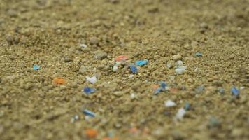 microplastics in het zand op het strand. concept van opwarming van de aarde en klimaatverandering. niet-recyclebare plastic vervuiling in het zand. foto