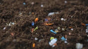 microplastics in de bodem. concept van opwarming van de aarde en klimaatverandering. niet-recyclebare plastic vervuiling in de bodem op het veld niet-recyclebare plastic vervuiling in de oceanen. foto