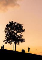 silhouet van vader moeder en dochter spelen bij zonsondergang in de avond tijd, gelukkige familie concept. foto