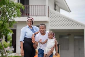 vrolijke afro-amerikaanse familie met bagage die het huis verlaat voor vakantie, geluksfamilieconcepten foto