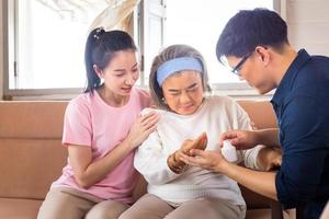 zoon en dochter van middelbare leeftijd zorgen voor een zieke senior moeder, geluk Aziatische familieconcepten foto