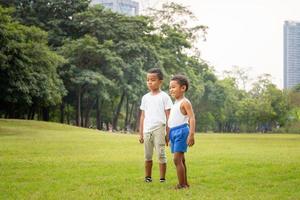 portret van twee gelukkige kinderen jongens grappig buiten spelen in een park, kinderen spelen concept. foto