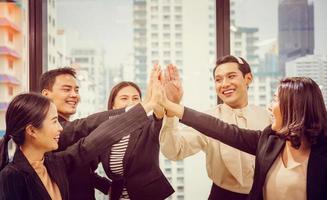 bedrijfsgroep viert na een ontmoeting, gelukkige zakenmensen steken de hand op samen met vreugde en succes, succesvol en teamwerkconcept foto