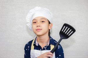 droomcarrièreconcept, portret van een gelukkige kinderchef die naar de camera kijkt met een onscherpe achtergrond foto