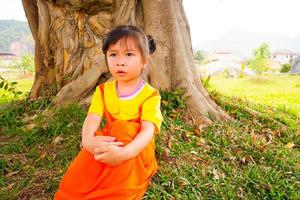 mooie babymeisje draagt geeloranje outfit gokowa outfit, mugunghwa in een openbaar park. meisjes en tiener mode jurk. foto