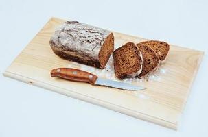 gesneden sneetjes brood en mes op een houten tafel foto