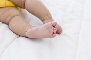 de voeten van de baby slapen in het bed. foto