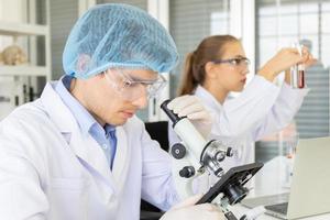 twee wetenschappers scheikunde technologie, biologie een nieuwe generatie wetenschappers die een glas met reagentia schudden en tests of onderzoek in laboratoria uitvoeren. foto