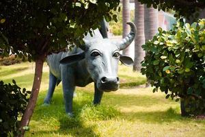 standbeeld van buffel staande op groen gras dat wordt gebruikt als een symbool voor mensen om te leren dat dit een dier is dat boeren gebruiken in de landbouw. foto