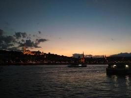 zonsondergang over de waterkant van boedapest, hongarije. gekleurde hemel nacht uitzicht op de rivier de Donau. foto