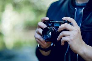 hand en camera van de fotograaf reizen in de bergen en natuurconcept fotograaf foto